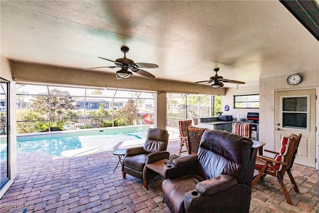 view of patio featuring a lanai, ceiling fan, and an outdoor living space