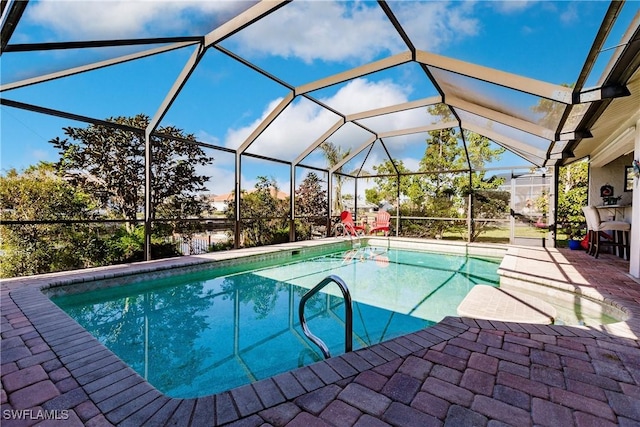 view of swimming pool with glass enclosure and a patio area