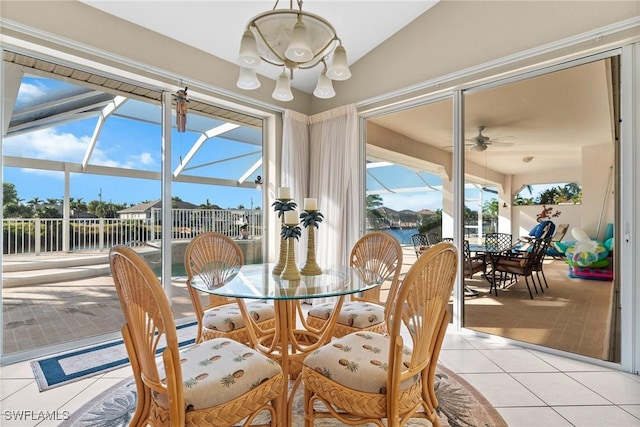 sunroom featuring ceiling fan and a water view