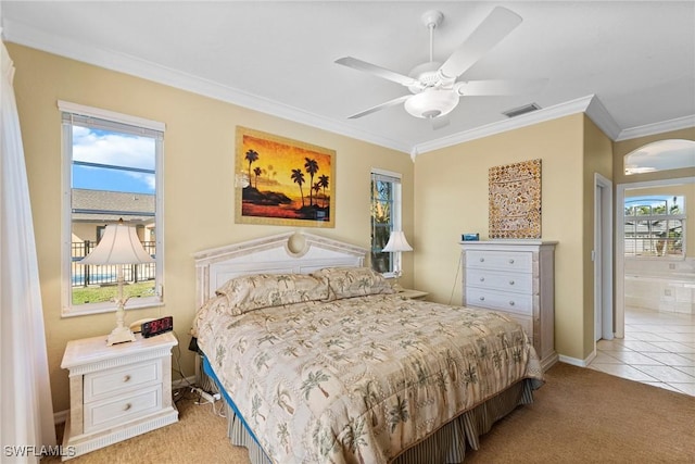 bedroom with light carpet, ceiling fan, ensuite bathroom, and ornamental molding