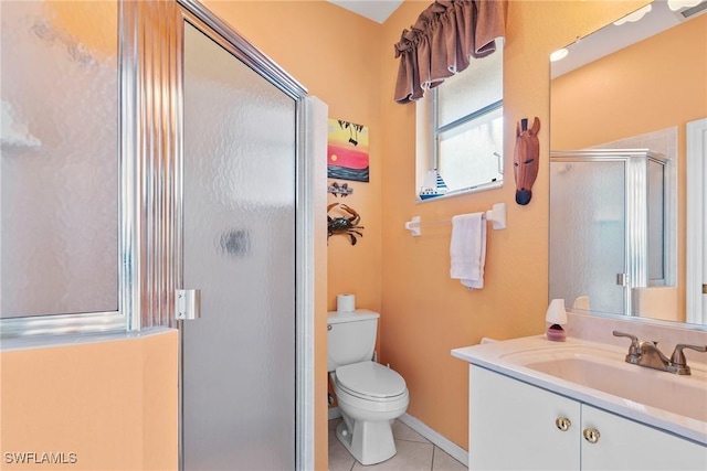 bathroom with tile patterned floors, a shower with door, vanity, and toilet