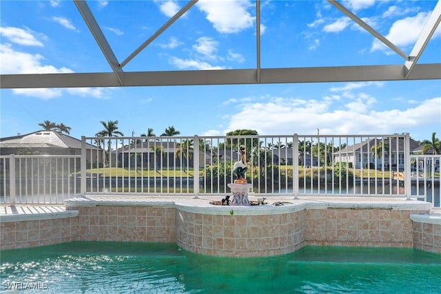 view of pool with a lanai and a water view