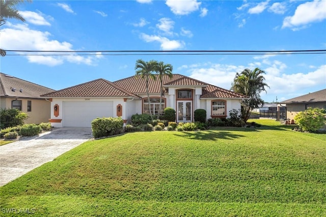 mediterranean / spanish house featuring a garage, a front yard, and french doors