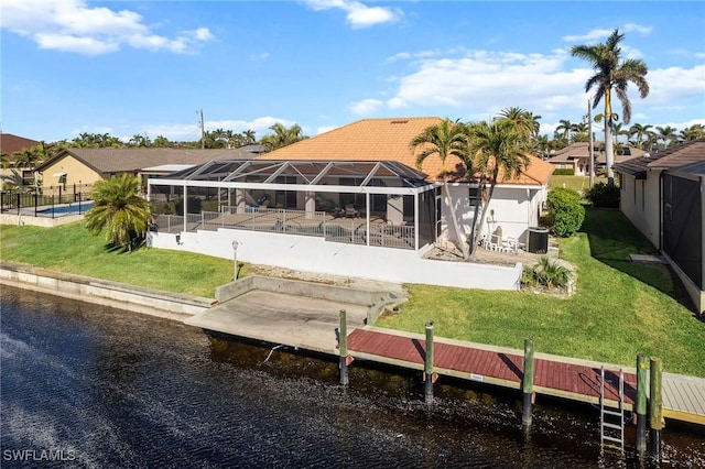 rear view of property featuring a lanai, a water view, a yard, and a patio