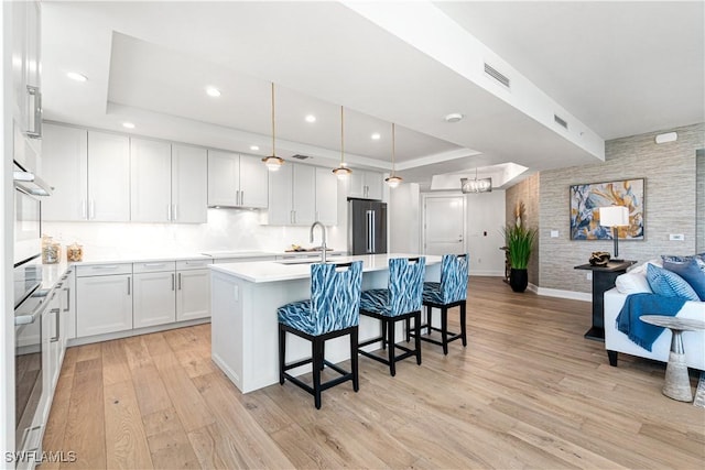 kitchen featuring white cabinets, stainless steel appliances, and a tray ceiling