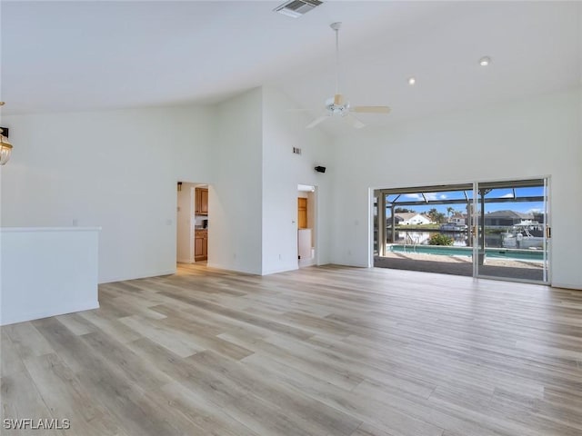 unfurnished living room with ceiling fan, high vaulted ceiling, and light hardwood / wood-style flooring