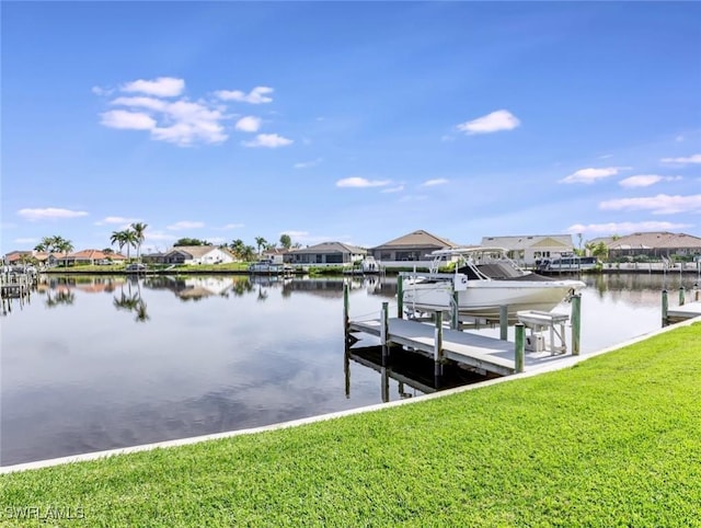 view of dock with a water view and a lawn