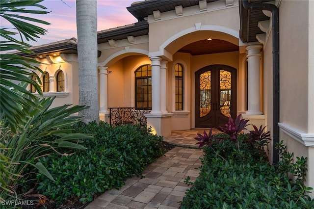 exterior entry at dusk featuring french doors