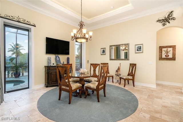 dining space featuring plenty of natural light, ornamental molding, a raised ceiling, and a notable chandelier