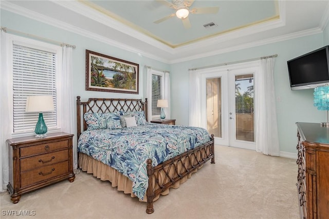 bedroom with ceiling fan, a tray ceiling, access to outside, french doors, and ornamental molding