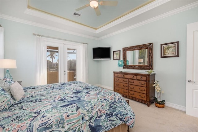 carpeted bedroom with ceiling fan, access to exterior, a raised ceiling, ornamental molding, and french doors