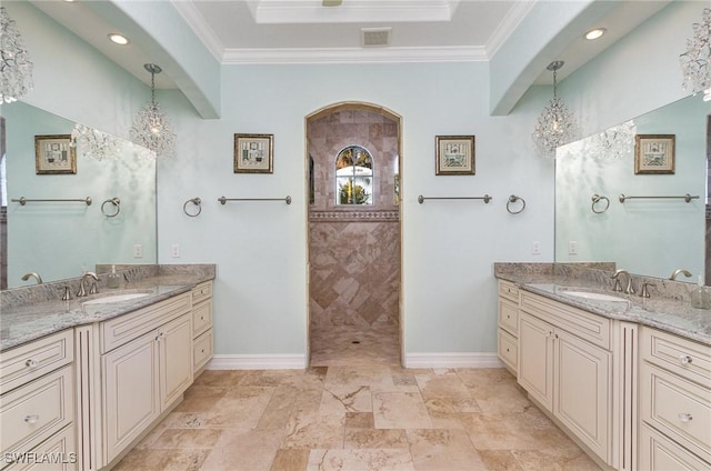 bathroom with vanity, crown molding, and a tile shower