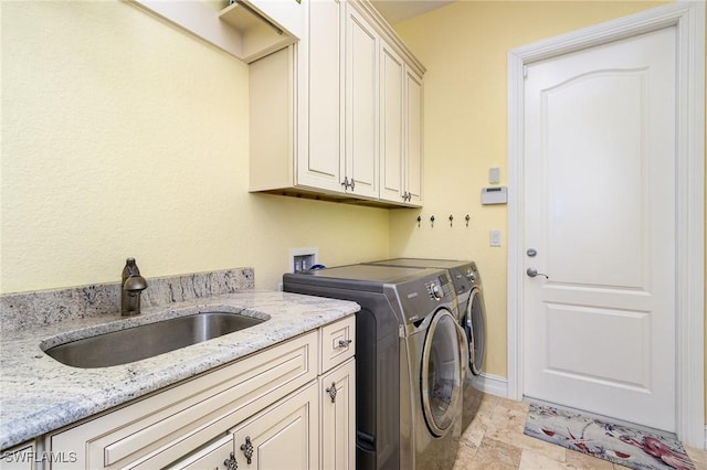 laundry area with washer and clothes dryer, sink, and cabinets