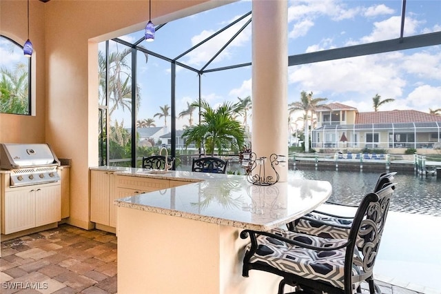 kitchen with decorative light fixtures, a water view, a wealth of natural light, and kitchen peninsula