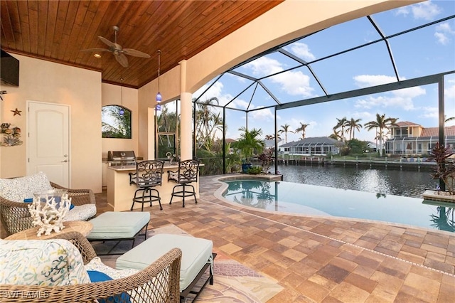 view of patio / terrace with a grill, area for grilling, glass enclosure, a water view, and a bar