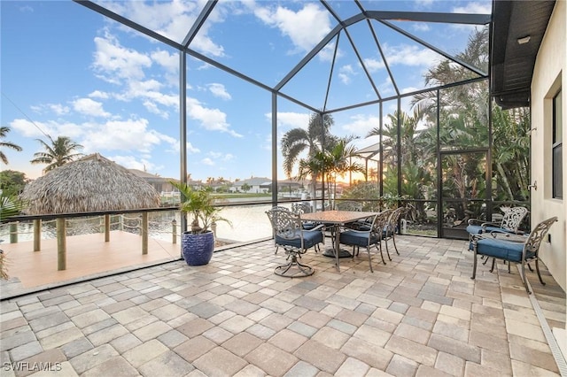 view of patio featuring a lanai, a gazebo, and a water view