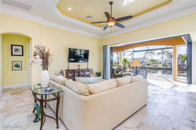 living room featuring ceiling fan, crown molding, and a raised ceiling