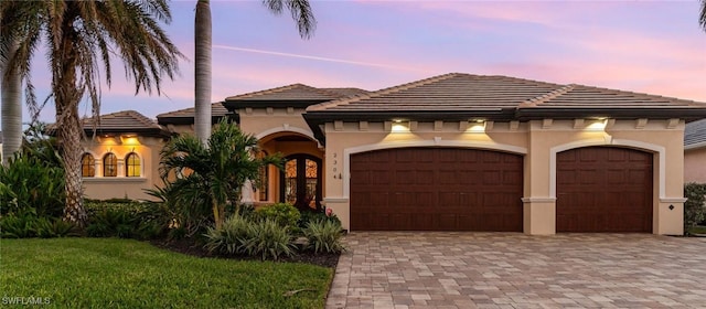 mediterranean / spanish-style house featuring a garage and french doors