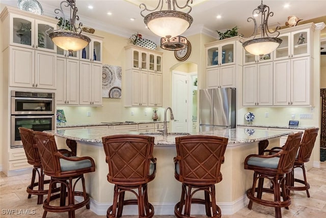 kitchen featuring a large island, stainless steel appliances, light stone countertops, pendant lighting, and sink