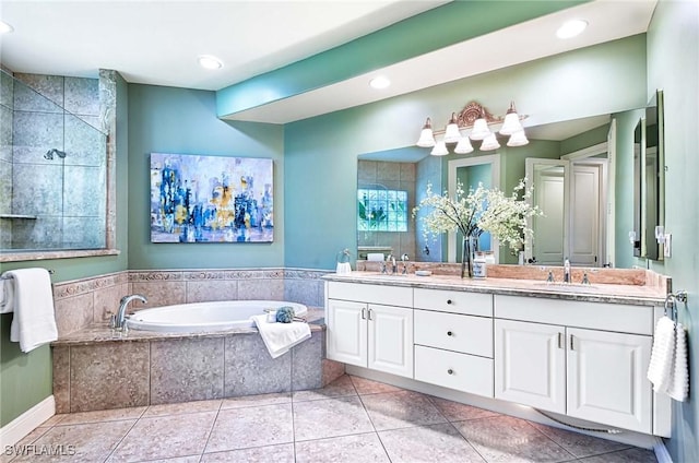 bathroom featuring vanity, tile patterned floors, and tiled tub