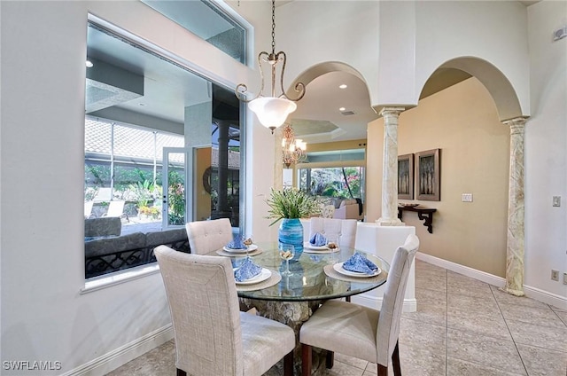 dining area with a chandelier, light tile patterned floors, ornate columns, and a healthy amount of sunlight