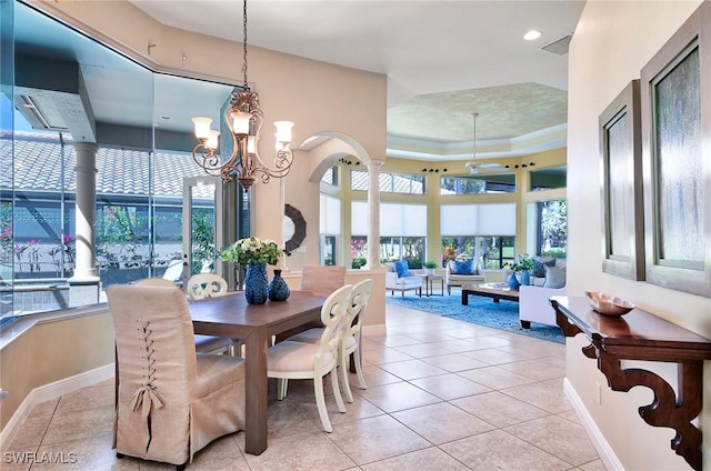 tiled dining space with a raised ceiling and a notable chandelier