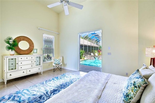 bedroom featuring ceiling fan, access to exterior, light tile patterned floors, and a high ceiling