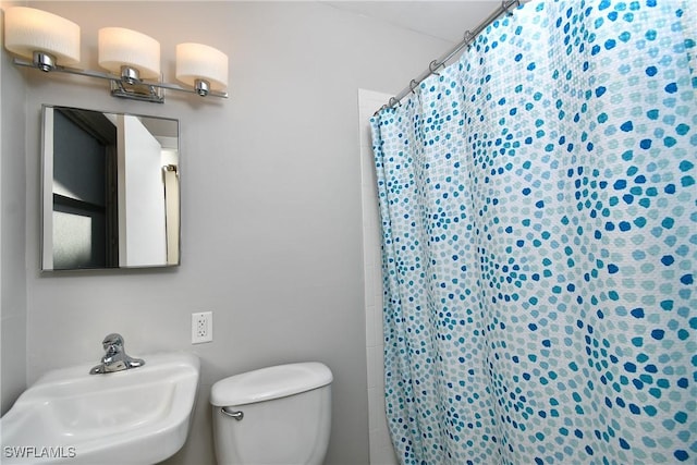 bathroom with toilet, sink, and walk in shower