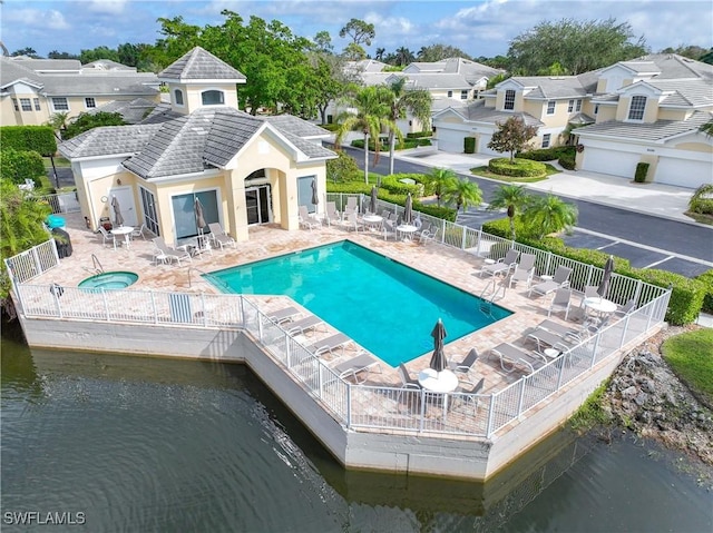 view of pool with a patio and a water view