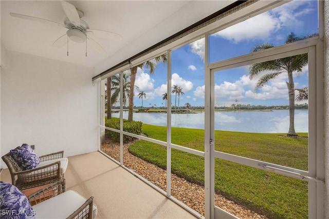 sunroom / solarium featuring ceiling fan and a water view