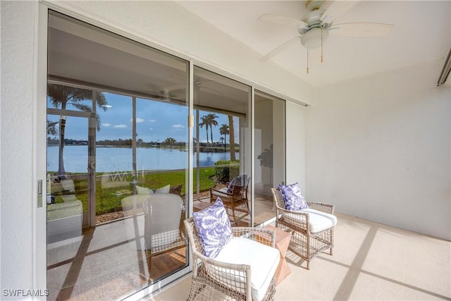 sunroom with ceiling fan, a water view, and a healthy amount of sunlight