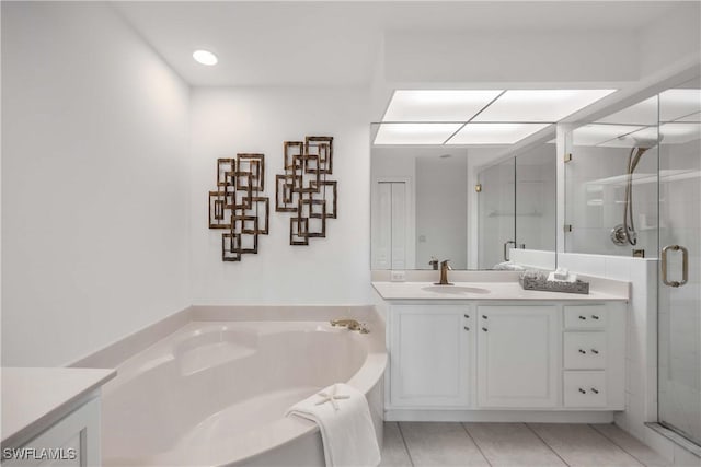 bathroom with tile patterned flooring, vanity, and plus walk in shower