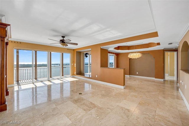 empty room featuring a water view, ornamental molding, a tray ceiling, and ceiling fan with notable chandelier