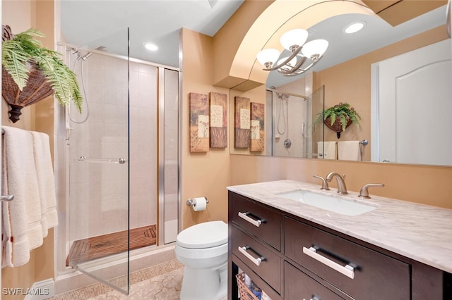 bathroom featuring vanity, walk in shower, an inviting chandelier, and toilet