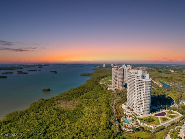 aerial view at dusk featuring a water view