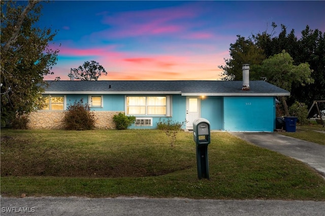 ranch-style home with a lawn