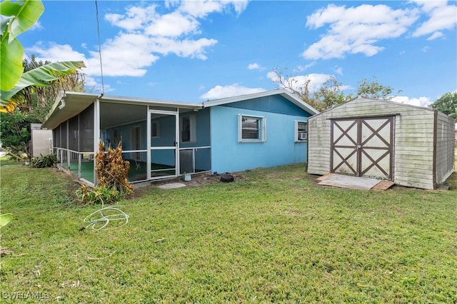 rear view of house featuring a sunroom, a storage shed, and a yard