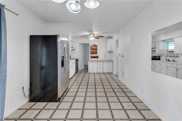 kitchen featuring range with electric stovetop, stainless steel fridge, white cabinets, and ceiling fan