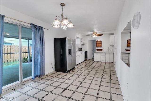 kitchen featuring ceiling fan with notable chandelier, white cabinetry, stainless steel appliances, and hanging light fixtures