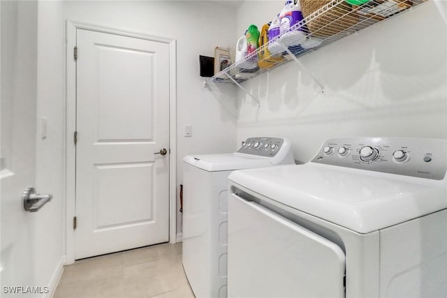 laundry room featuring separate washer and dryer and light tile patterned floors