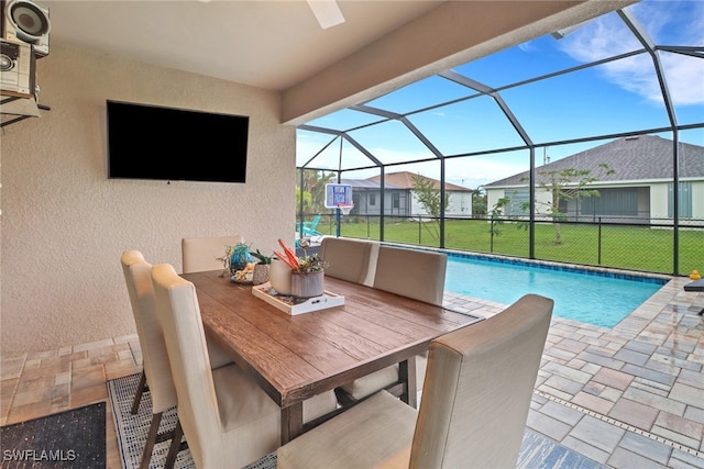 view of pool featuring a patio, glass enclosure, and a lawn