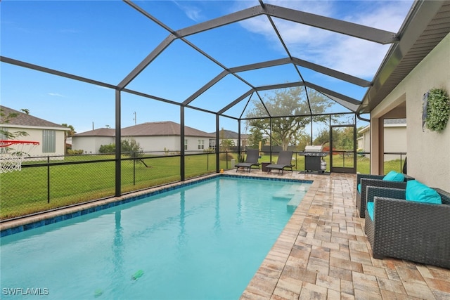 view of pool with a patio, a yard, glass enclosure, and grilling area