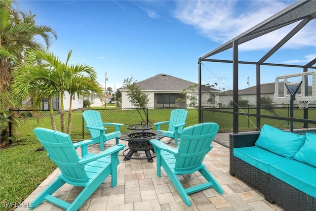 view of patio featuring glass enclosure and an outdoor living space with a fire pit