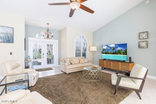 living room featuring french doors, ceiling fan with notable chandelier, high vaulted ceiling, and light tile patterned floors