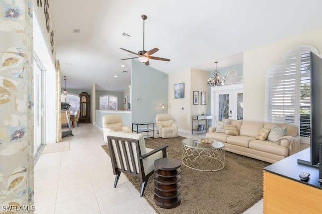 tiled living room featuring french doors and ceiling fan with notable chandelier