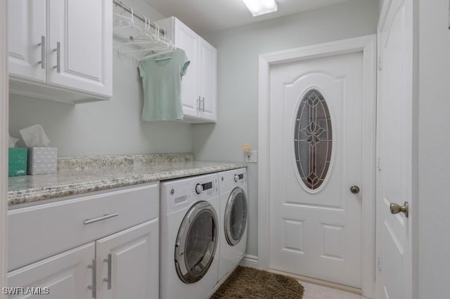 clothes washing area featuring washer and dryer and cabinets