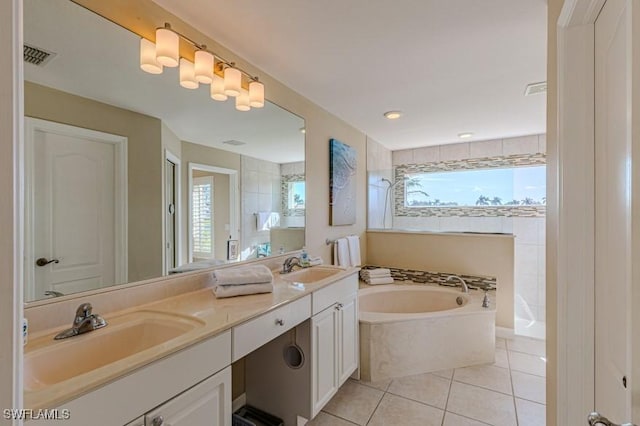 bathroom featuring a bathing tub, tile patterned flooring, a healthy amount of sunlight, and vanity