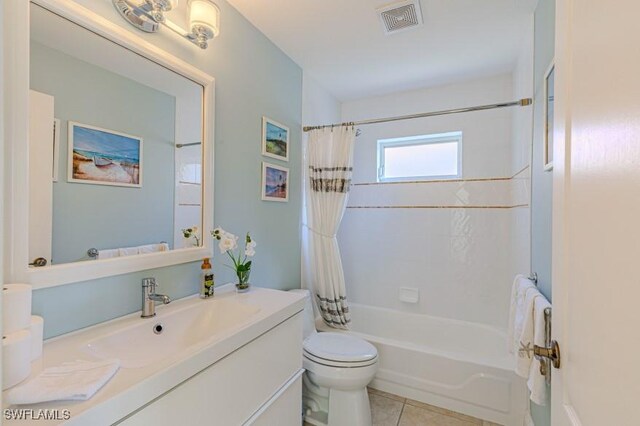 full bathroom with tile patterned floors, vanity, toilet, and shower / bath combo with shower curtain