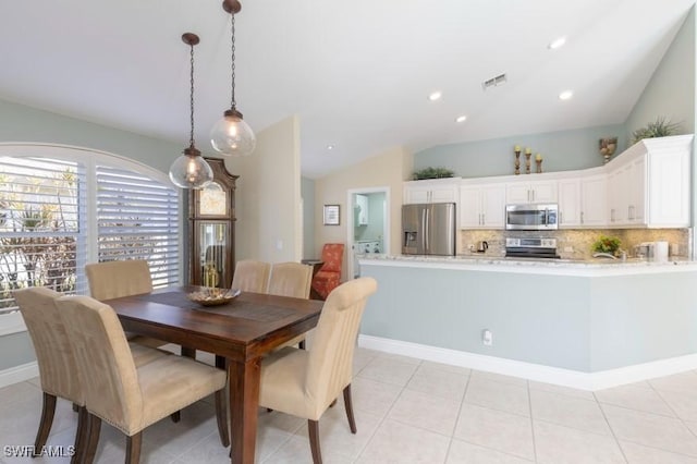 tiled dining area featuring vaulted ceiling