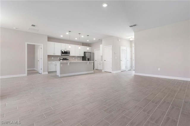 unfurnished living room with light hardwood / wood-style floors and sink